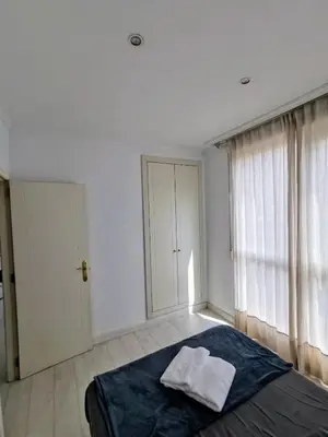 a white bedroom with a bed and a window at Apartment Ruzafa Market 7C in Valencia