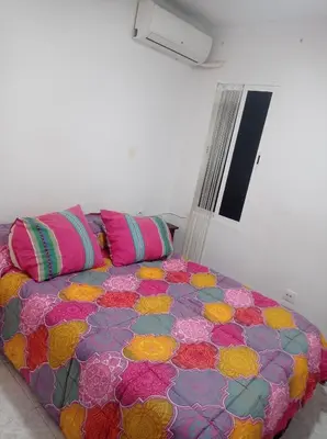 a bed with colorful pillows in a room at Valencia 2 en piso familiar compartido in Valencia