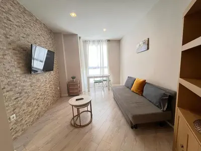 a living room with a couch and a tv on a brick wall at Apartment Ruzafa Market 8B in Valencia