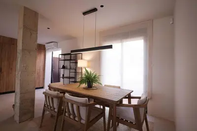 a dining room with a wooden table and chairs at Casa unifamiliar con jardín en la playa in Mareny Blau