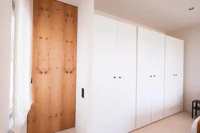 a room with white cabinets and a wooden door at Casa unifamiliar con jardín en la playa in Mareny Blau