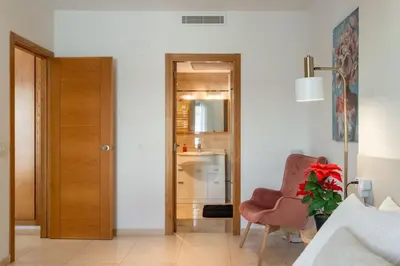 a living room with a chair and a door at Valencia Beach Vibe - Oceanfront escape in Valencia