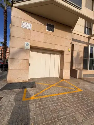a building with two garage doors in a parking lot at Valencia Beach Vibe - Oceanfront escape in Valencia