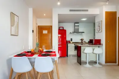 a kitchen with a red refrigerator and a table and chairs at Valencia Beach Vibe - Oceanfront escape in Valencia