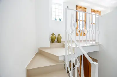 a white staircase with vases in a white room at Gatova Sunset Retreat in Gátova