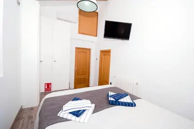 a bedroom with a bed with a tv on the wall at En el corazón de Sagunto in Sagunto