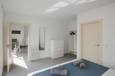 a white bedroom with a blue bed and a mirror at Your Apartment In The Center-Ruzafa 8C in Valencia