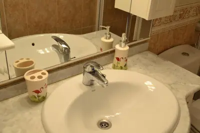 a bathroom with a sink and a toilet and a mirror at Pobla de Farnals BEACH APARTMENT in Puebla de Farnals