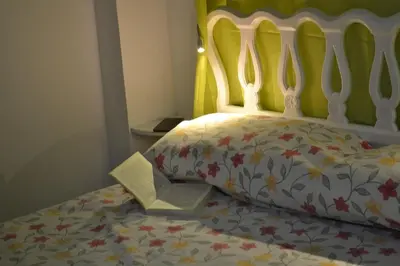 a bed with a comforter with a book on it at Pobla de Farnals BEACH APARTMENT in Puebla de Farnals