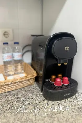a coffee maker sitting on a counter with bottles of water at BEACH VALENCIA LUXURY D7-21 Apartment with terrace and sea views with two rooms in Valencia