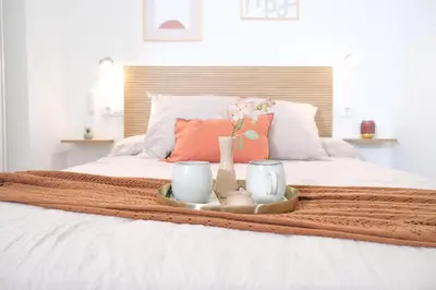a tray with vases and flowers on a bed at Suite near to Marathon - City of Arts & Sciences in Valencia