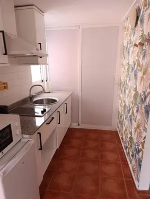 a kitchen with white cabinets and a tile floor at Estudio recién decorado en el mejor centro histórico in Valencia