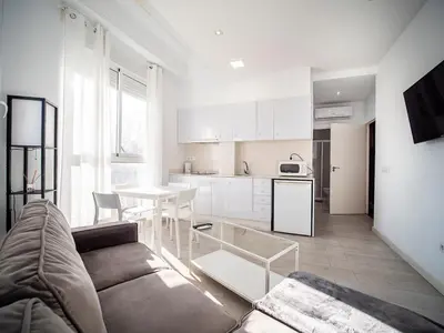 a living room with a couch and a kitchen at Apartment Ruzafa Market 9C in Valencia