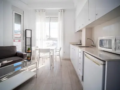 a white kitchen with a couch and a table at Apartment Ruzafa Market 9C in Valencia