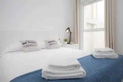 a bedroom with a white bed with towels on it at Quart Apartment in Valencia