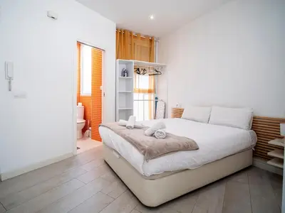 a white bedroom with a large bed with white pillows at Tu Apartamento En El Centro-Ruzafa 9D in Valencia