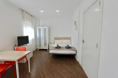 a bedroom with a bed and a desk and a television at Tu Estudio En El Centro-Ruzafa 10A in Valencia