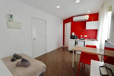 a kitchen with red walls and a table and a tv at Tu Estudio En El Centro-Ruzafa 10A in Valencia