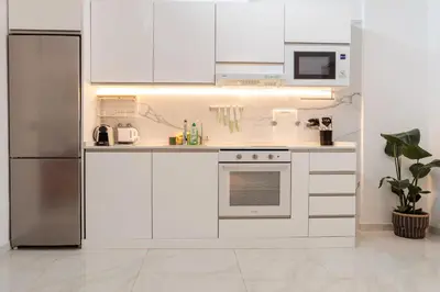 a kitchen with white cabinets and a stainless steel refrigerator at Top Floor 2 Bedroom Apartment with Terrace in Valencia