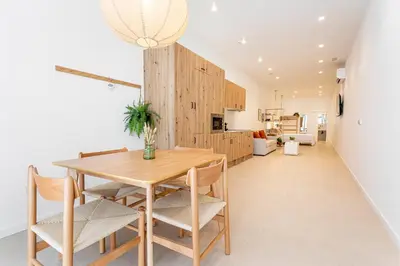 a kitchen and dining room with a wooden table and chairs at B - Design apartment at El Grao close to the beach in Valencia