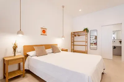 a white bedroom with a large bed and a table at B - Design apartment at El Grao close to the beach in Valencia