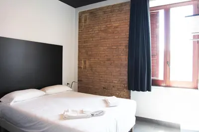 a bedroom with a bed and a brick wall at Soho Valencia in Valencia
