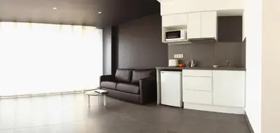 a kitchen with white cabinets and a couch in a room at Soho Valencia in Valencia
