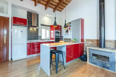 a large kitchen with red cabinets and a fireplace at Penthouse apartment historical center in Valencia