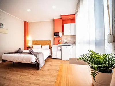 a bedroom with a bed and a kitchen at Estudio En El Centro-Ruzafa 10D in Valencia