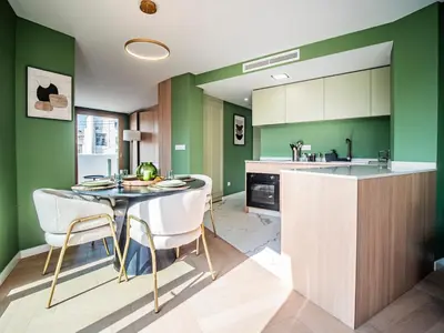 a kitchen with green walls and a table and chairs at Tu Penthouse En El Centro - Ruzafa 11C in Valencia