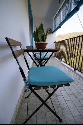 a chair and a table with a plant on a balcony at Casa vistas al rio in Navajas