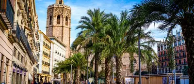 a tall building with a clock tower and palm trees at Plaza la REINA 3th floor & no elevator in Valencia