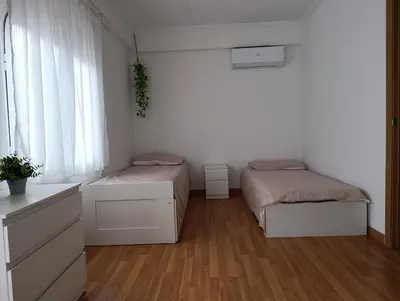 a white room with two beds and a window at El otro cielo Playamonte in Navarrés