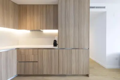 a kitchen with wooden cabinets and a refrigerator at ApartUP Port Marina Azura in Valencia