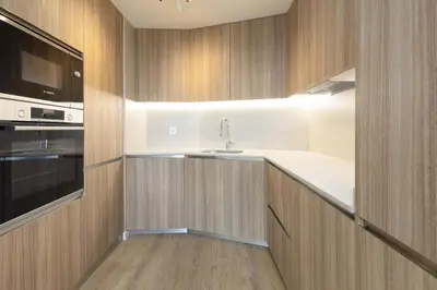 a kitchen with wooden cabinets and a sink at ApartUP Port Marina Azura in Valencia