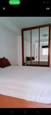 a bedroom with a white bed and a mirror at Piso in Valencia