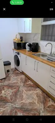 a kitchen with a counter with a sink and a washing machine at Piso in Valencia