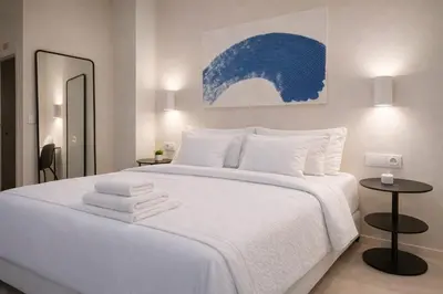 a bedroom with a large white bed with towels on it at Roca Collection MSuites in Valencia