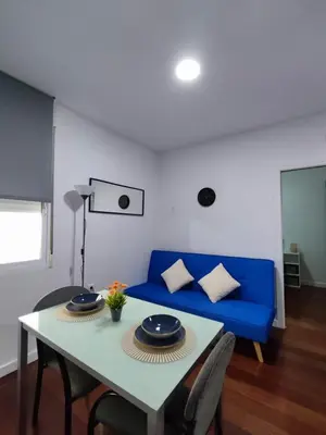 a living room with a blue couch and a table at Benimaclet JTM in Valencia
