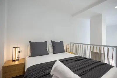 a bedroom with a large bed with gray pillows at Estudio con Altillo en Malilla cerca de La Fe in Valencia
