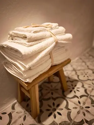 a stack of white towels sitting on a stool at Casa Abadía Alojamiento completo boutique cerca de Valencia in Alfarp
