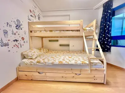 a bunk bed with a ladder in a room at Beachfront Family Apt in Valencia