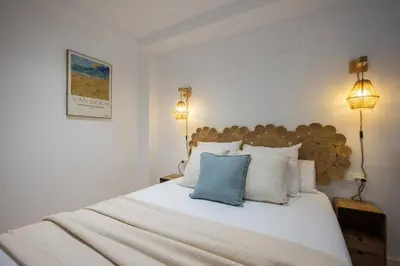 a bedroom with a large white bed with two lamps at Suite de diseño en Roig Arena in Valencia