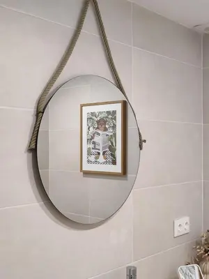 a round mirror in a bathroom with a picture at Loft acogedor junto al Roig Arena in Valencia