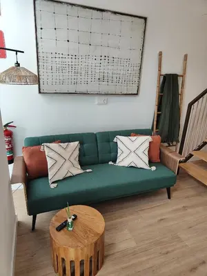 a living room with a green couch and a table at Loft acogedor junto al Roig Arena in Valencia