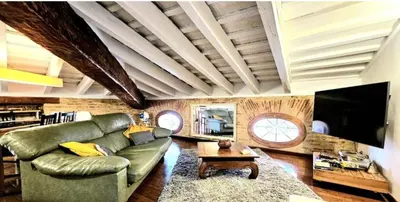 a living room with a green couch and a tv at Gran Ático Premium del Siglo XVI con Tres Terrazas Privadas Hasta 7 Huéspedes en Ciutat Vella in Valencia