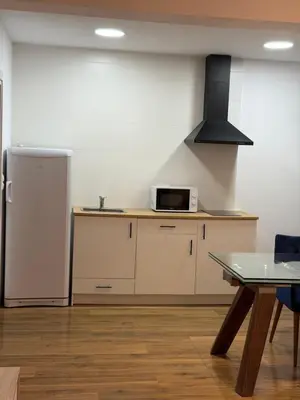 a kitchen with a refrigerator and a table at Apartamento junto a la playa in Valencia