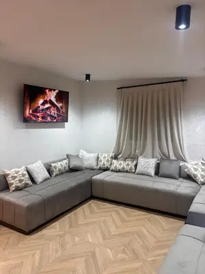 a living room with a large couch in front of a window at Apartamento cerca de la playa in Puerto de Sagunto