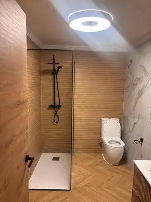 a bathroom with a toilet and a glass door at Apartamento cerca de la playa in Puerto de Sagunto