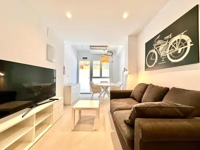 a living room with a couch and a flat screen tv at Casa Rosario - Apartamento reformado en El Cabañal in Valencia